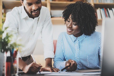 two young coworkers working together in a modern office.black business people discussing new startup project.horizontal,blurred