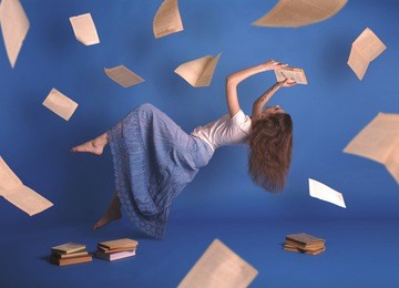 surreal creative design, levitation. flying woman. levity people. reading girl. pages of books flying in the air. floating in the air magic book.
