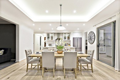 modern dining room with hanging lamps on, there are chairs and table setup with fancy items on the wooden floor
