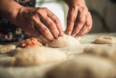 homemade cakes of the dough in the women's hands. the process of making pie dough by hand
