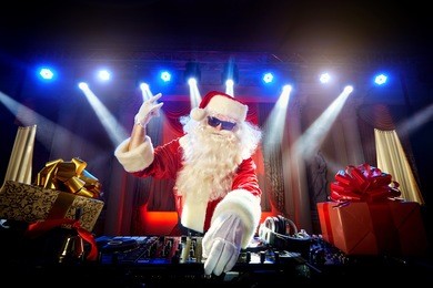 dj santa claus mixing up some christmas event.  disco light around fun, colorful atmosphere. musical new year.