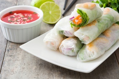vietnamese rolls with vegetables, rice noodles and prawns on wooden background
