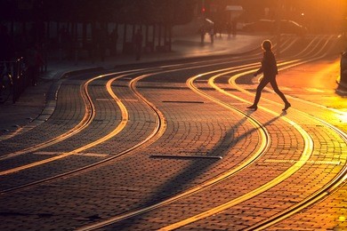 street photography of blurred woman walking on tram railway during the sunset in bordeaux city, france.  vintage style and grain texture 