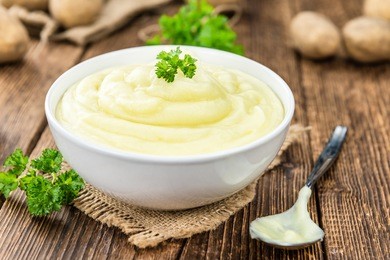 potato mash on rustic wooden background (close-up shot)