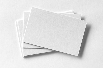 mockup of business cards fan stack at white textured paper background.