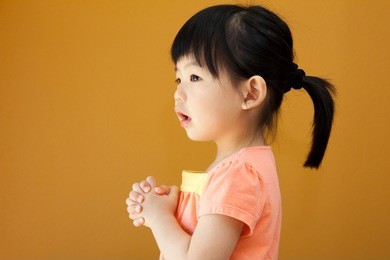 portrait of a little asian baby child girl is praying