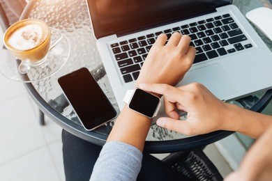 woman using smart watch in coffee shop, modern city lifestyle