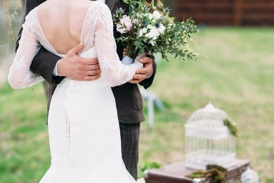 just married couple dancing valse outdoor, free space. bride and groom hugs, blurred green grass background. first wedding dance concept