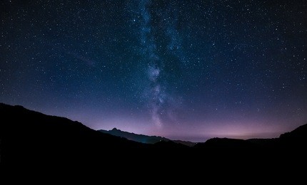 purple night sky stars. milky way galaxy across mountains. 