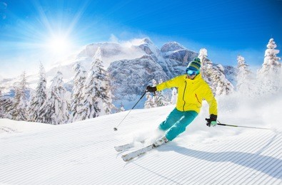 skier skiing downhill in high mountains during sunny day.