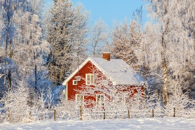 red cottage in winter forest with frost and snow