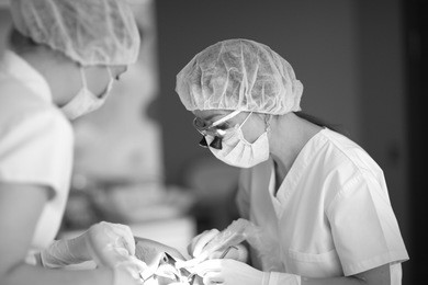 dentist and his assistant prepare the patient for the installation of the implant