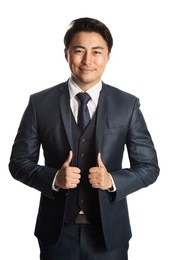 handsome and well dressed businessman in a suit, tie and vest, standing against a white background smiling towards camera.
