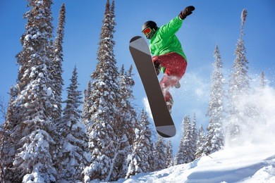 snowboarder jumps in forest. freeride snowboarding in sheregesh ski resort