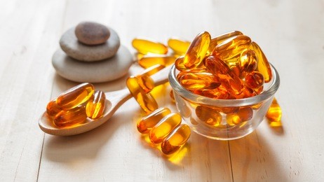 fish oil capsules on wooden background and texture, vitamin d supplement, selective focus