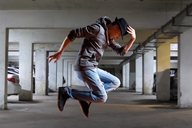 young man break dancing on wall background