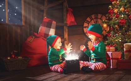 happy children brother and sister  elf, helper of santa with a christmas  magic  gifts