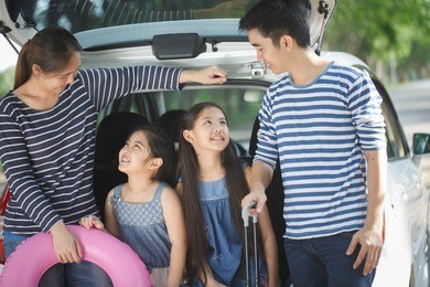 happy asian family with mini van are smiling and preparing for travel on vacation