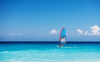 windsurfing. lonely surfer exercising on blue water. 