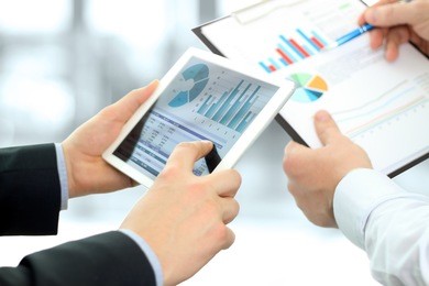 business colleagues working and analyzing financial figures on a digital tablet