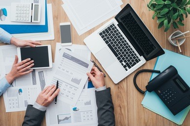 business team working at office desk and analyzing financial reports, finance and accounting concept, top view