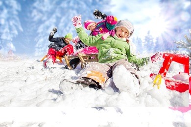 happy children sledding at winter time. group of children spending a nice time in winter.