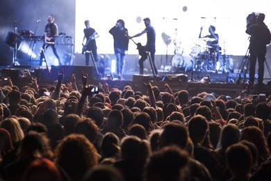 crowd at concert - cheering crowd in front of bright colorful stage lights