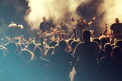 crowd at concert - cheering crowd in front of bright colorful stage lights