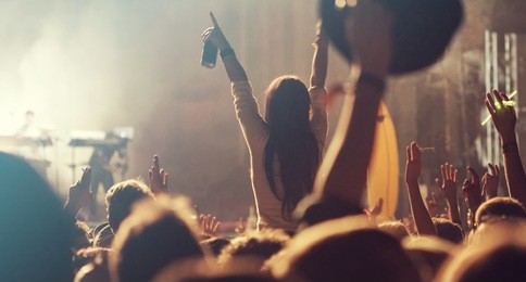 crowd at concert - cheering crowd in front of bright colorful stage lights