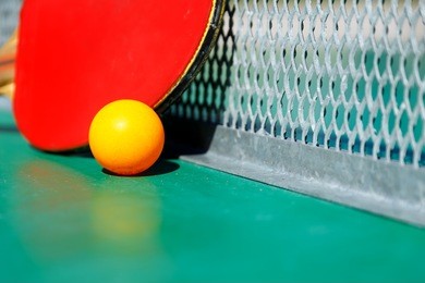 details of pingpong table with playing equipment and yellow ball