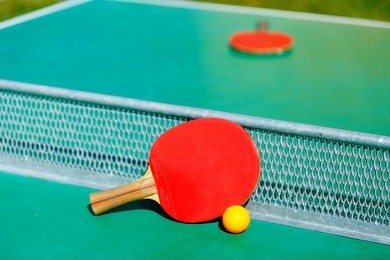 details of pingpong table with playing equipment and yellow ball