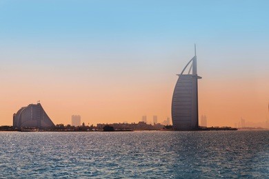 silhouettes of buildings burj al arab and jumeirah hotels on jumeirah beach in dubai. modern architecture, luxury beach resort, summer vacation and tourism concept. view from boat. al arab. dubai.