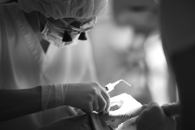 dentist with an assistant perform medical manipulations on the patient's upper jaw