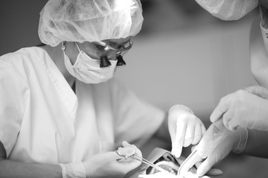 dentist and his assistant perform surgical procedures on the patient's lower jaw