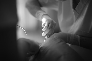 hands of dentist at the time of therapeutic manipulation with a surgical instrument