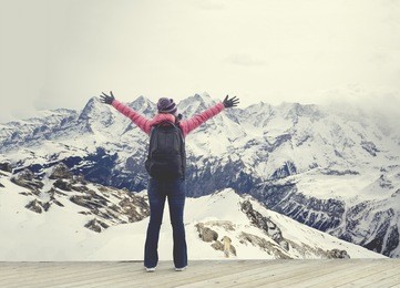 happy young girl traveler ,woman raising hands standing in view of the eiger, monch and jungfrau peaks from the schilthorn,bernese alps, switzerland,europe,selective focus,vintage color