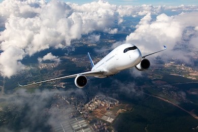 white passenger plane climbs through the clouds. aircraft is flying high above the city.