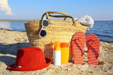 beach bag, sandals, hat, sunscreen cream and sunglasses on sea coast