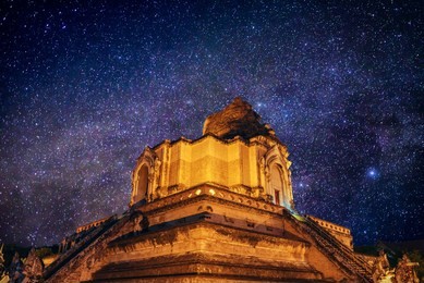 ancient pagoda wat chedi luang temple in the night with milky way in  stars field , chiang mai , thailand 