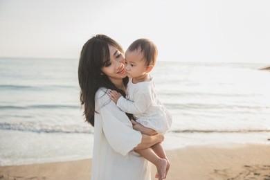 beautiful mother and baby outdoors. mum and her child together enjoying sunset