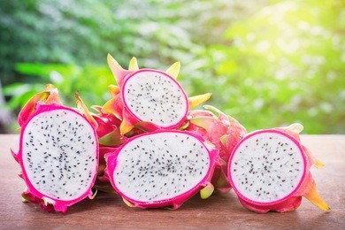 dragon fruit. vivid and vibrant dragon fruit on green bokeh background. dragon fruit has been popular for health care in natural light with blurred background effect of trees in the garden.