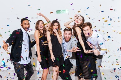 group of happy young people celebrating and having fun together over white background