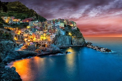 manarola, liguria, italy. the wonderful manarola village as you can see it from the mountain above. quiet sky and peaceful sea, during sunset.