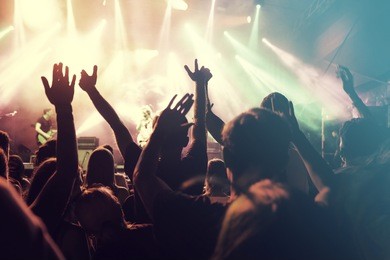 crowd at concert - cheering crowd in front of bright colorful stage lights