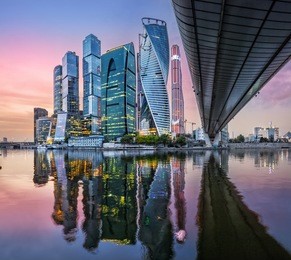 skyscrapers in moscow-city with reflection in the moscow river in the sunset pink sky
