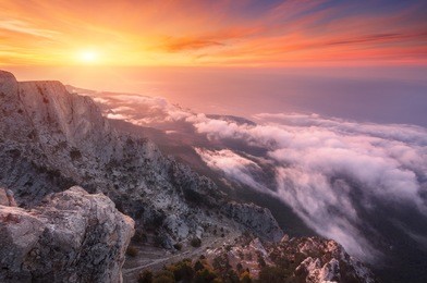 mountain landscape at sunset. amazing view from the mountain peak on rocks, low clouds, blue sky and sea in the evening. colorful nature background. adventure. travel in crimea. beautiful scenery
