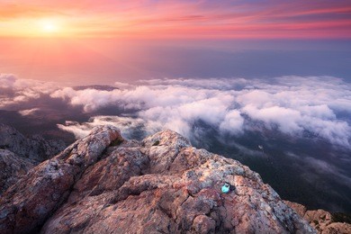 mountain landscape at sunset. amazing view from the mountain peak on rocks, low clouds, blue sky  in the evening. colorful nature background. adventure. travel in crimea. beautiful scenery at twilight