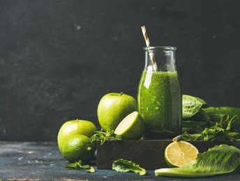 green smoothie with apple, romaine lettuce, lime and mint, dark blue background, selective focus, copy space. detox, dieting, clean eating, vegetarian, vegan, fitness diet or healthy lifestyle concept