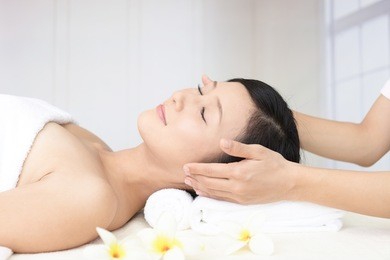 beautiful young woman receiving facial massage