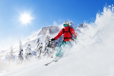 freeride skier with rucksack running downhill in freeze motion of snow powder.